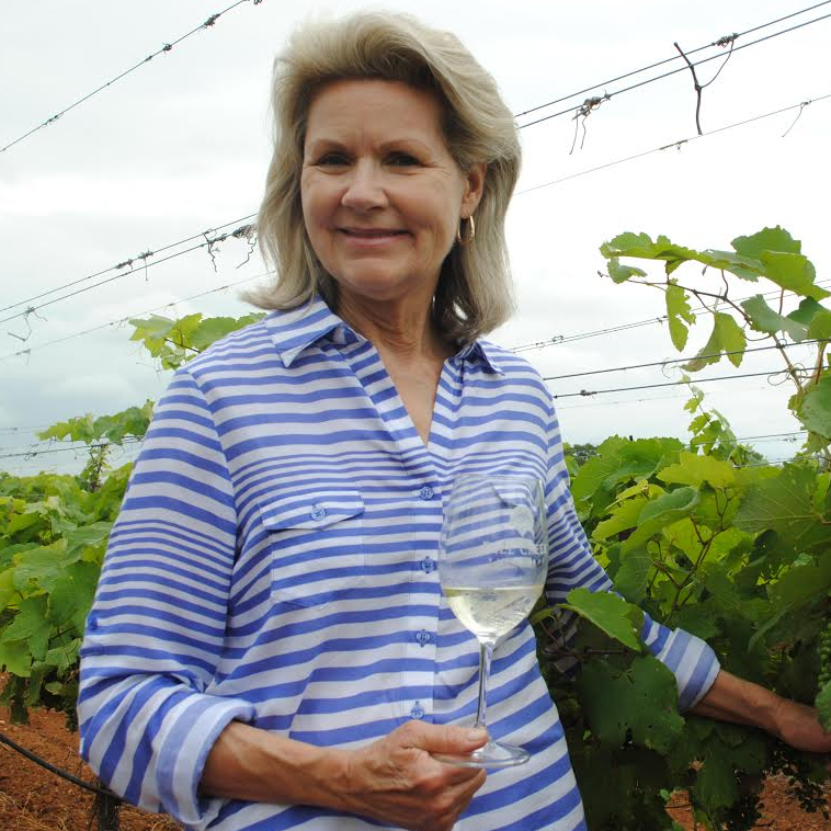 susan auler smiling with a glass of white wine